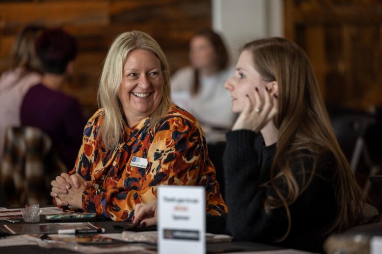 two females engage in conversation at a team event