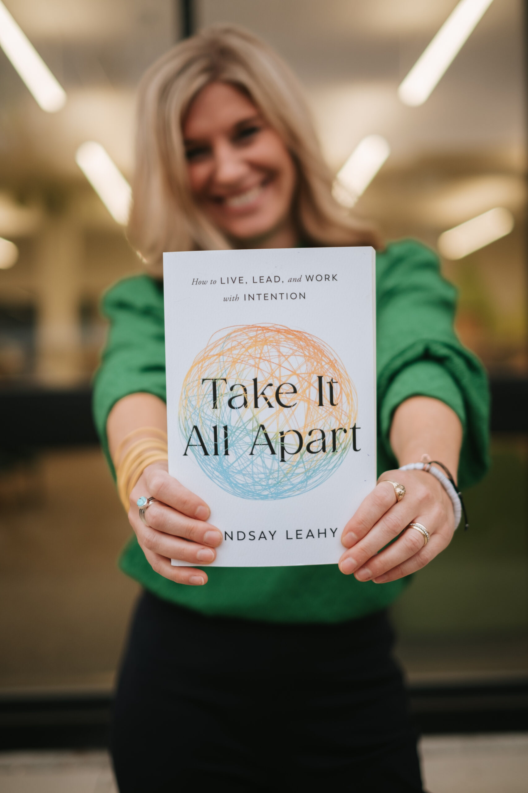 Woman holding book with title Take It All Apart