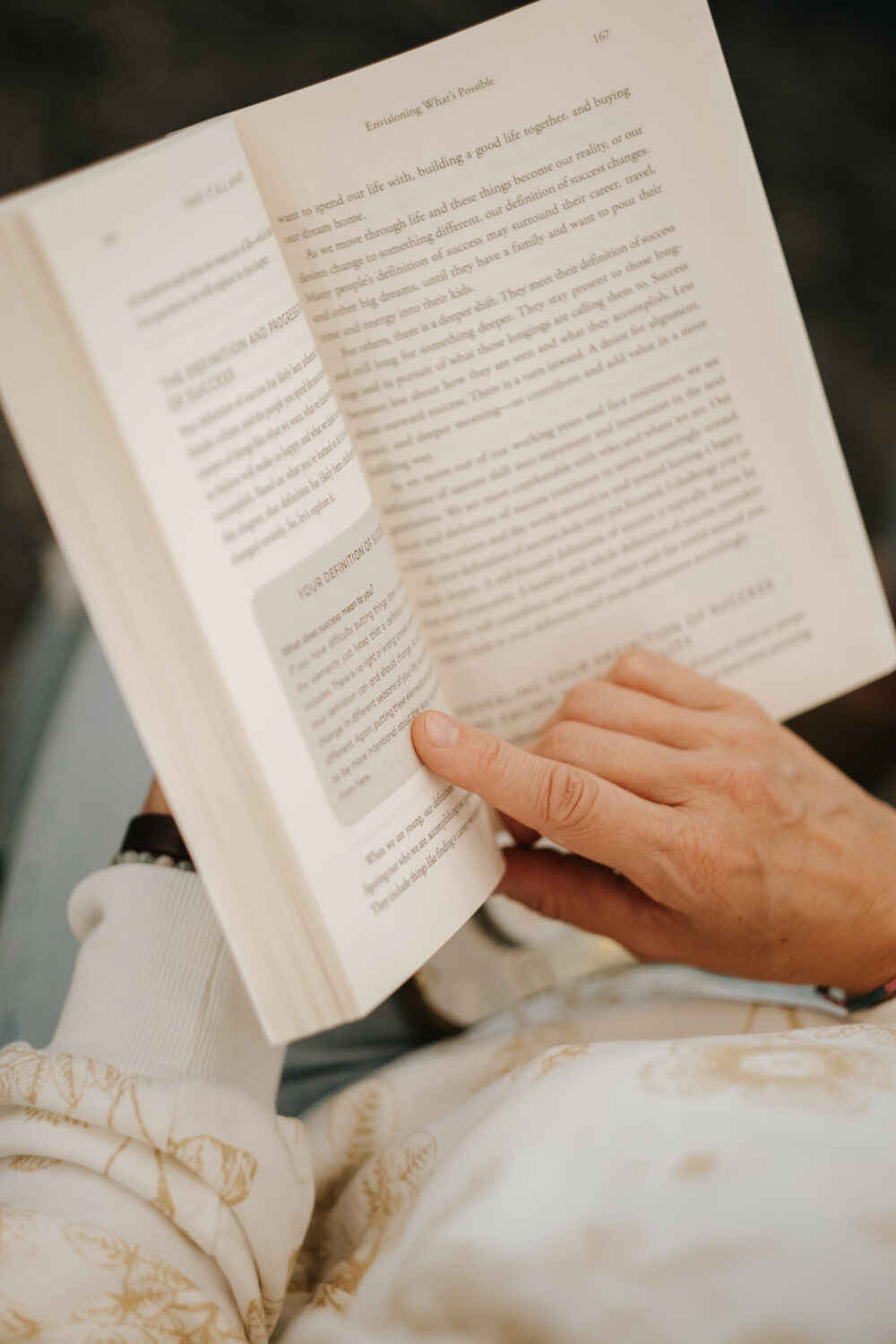 Woman pointing to passage on a page of the book Take It All Apart